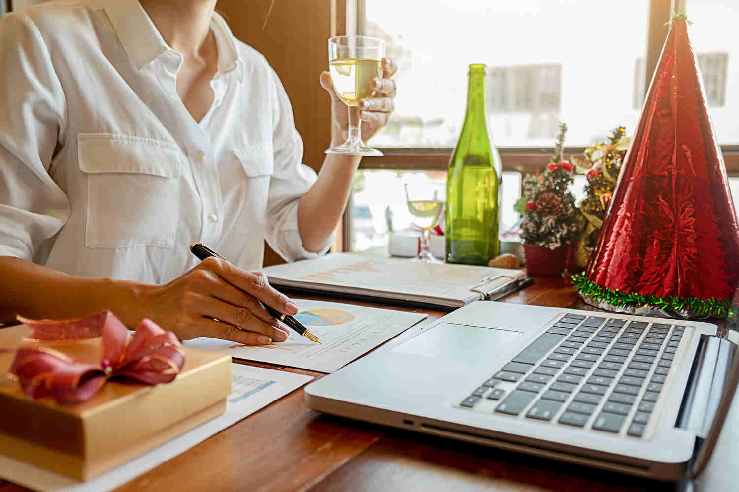Winery businesswoman having wine while doing accounting works