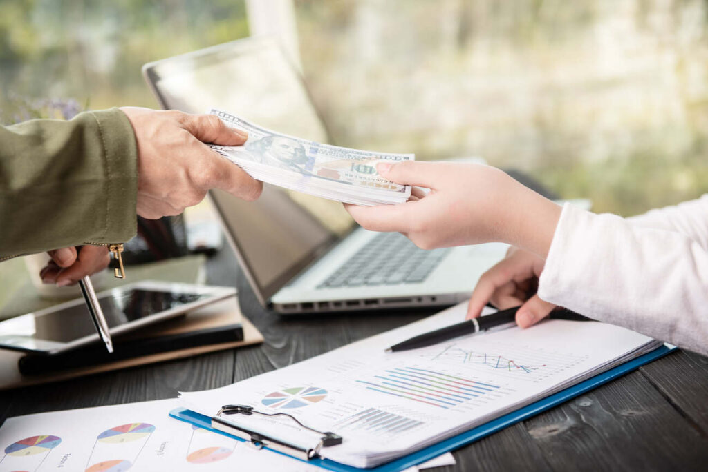 businessman giving salary to his employee while making contract