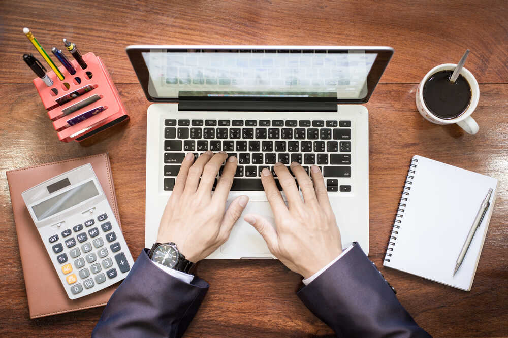 experienced bookkeeper working on his laptop for his client