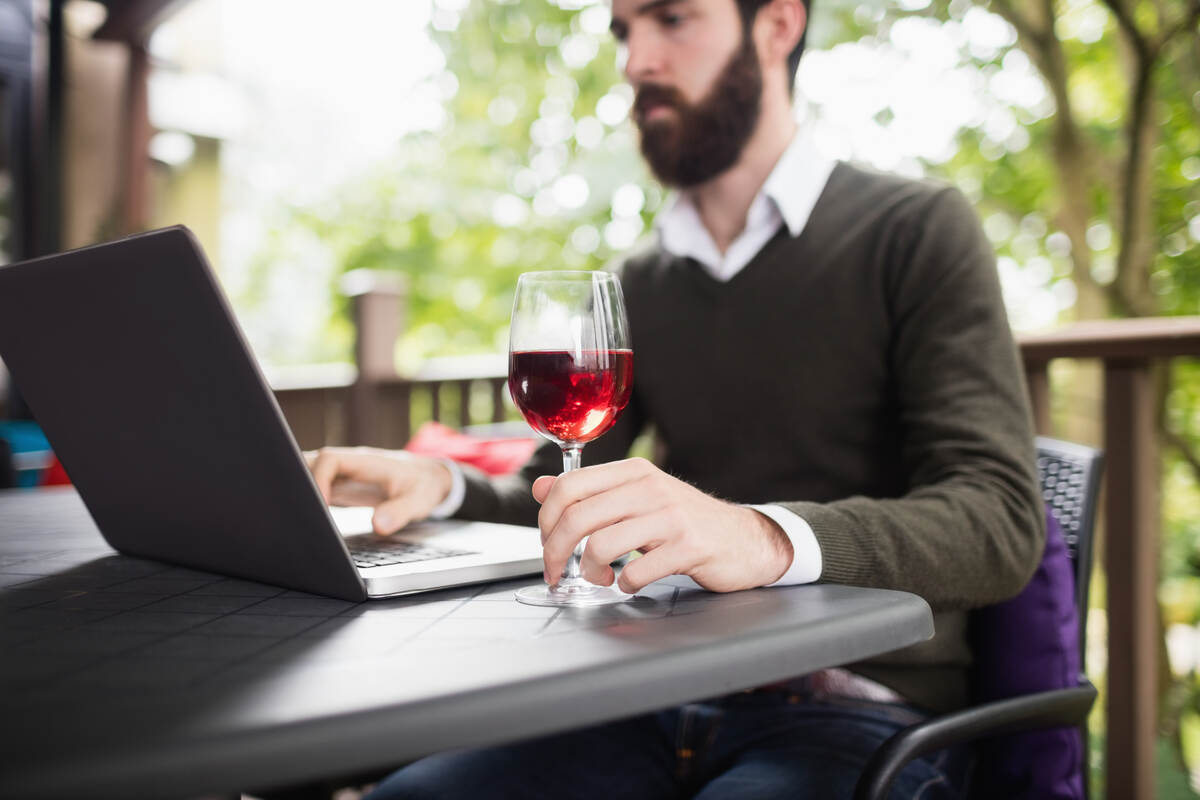 man using laptop while calculating reconciliation for winery