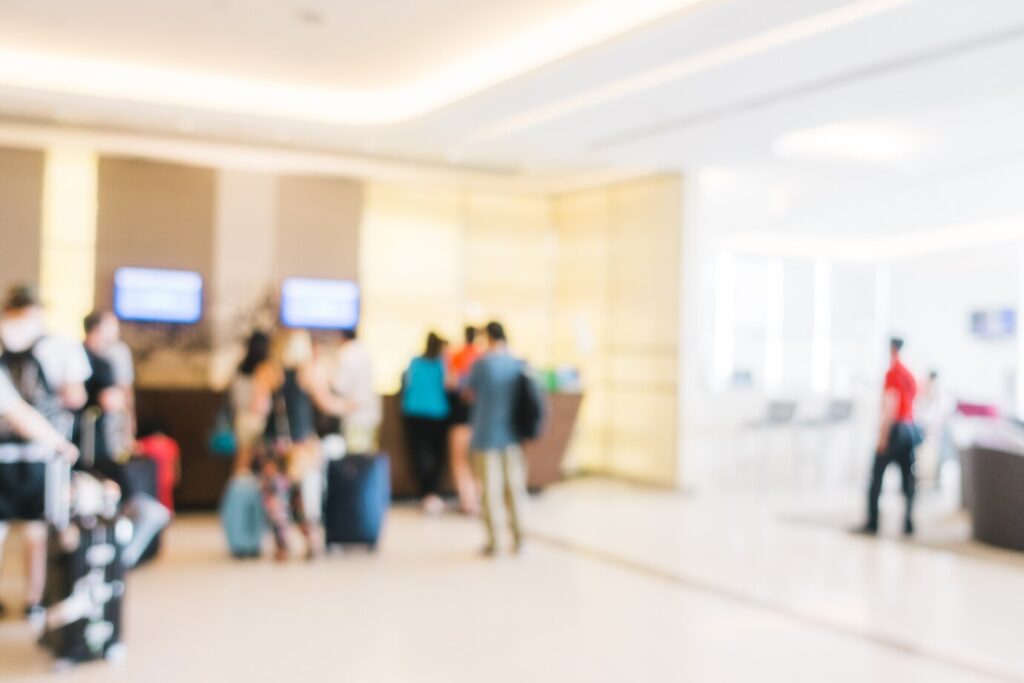 blurred background people waiting with luggage